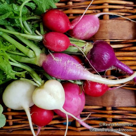 This photo is from "How to Grow Spring and winter Radishes" by Reese Amorosi for GlamorosiCooks.com. It shows pink, purple and white heirloom Easter Egg Radishes that were harvested from Reese's garden. The radishes are in a wicker basket.