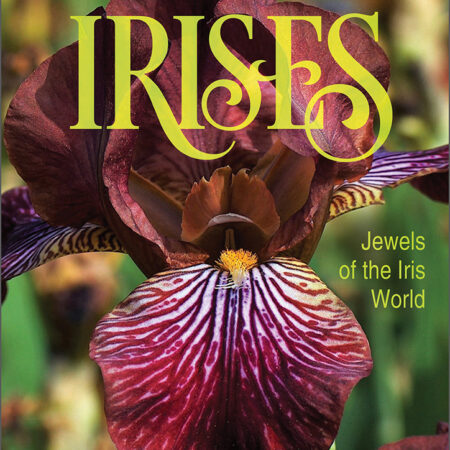 This photo shows the cover of the book titled Dwarf and Median Bearded Irises Jewels of the Iris World by Kevin C. Vaughn. It features a closeup of a burgundy-purple colored flower against a green background. Photo provided by Schiffer Publishing to for a book review at GlamorosiCooks.com