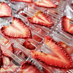 This photo shows the completed recipe for Dried Strawberries - Dehydrator Method by Reese Amorosi for GlamorosiCooks.com. The sliced strawberries look like hearts.