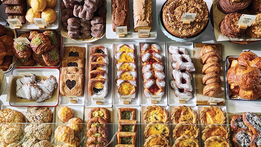 This photo featured in a review at GlamorosiCooks.com is from the cookbook MORNING BAKER (W. W. Norton & Company) by Roxana Jullapat with Ari Smolin. It shows three horizontal rows of baked goods. Photo by Kristin Teig.